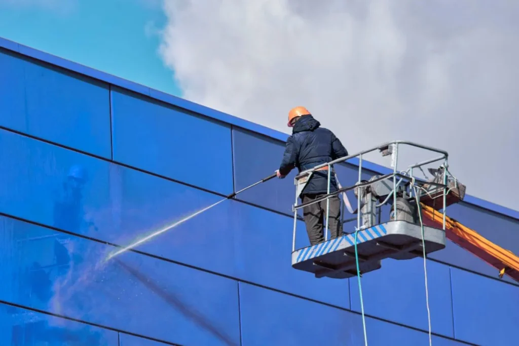 Nhân viên vệ sinh sử dụng xe nâng để tiếp cận và làm sạch tường cao tầng nhanh chóng, an toàn.